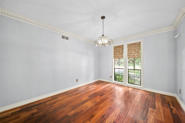 spare room featuring hardwood / wood-style flooring, ornamental molding, and a chandelier