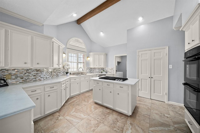 kitchen with sink, white cabinetry, a center island, double oven, and beam ceiling