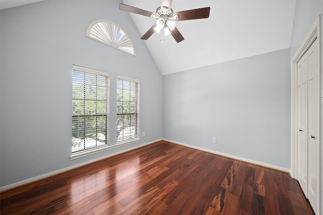 unfurnished bedroom featuring ceiling fan, dark wood-type flooring, high vaulted ceiling, and a closet