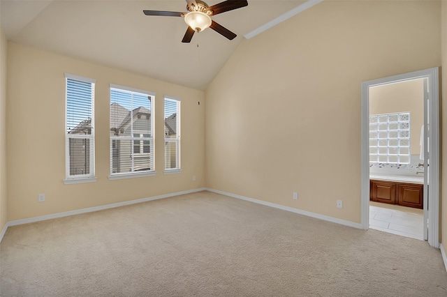 carpeted empty room with ceiling fan and high vaulted ceiling