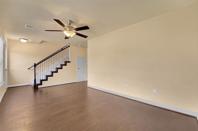 empty room with ceiling fan and dark hardwood / wood-style flooring