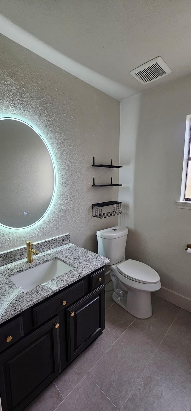 bathroom featuring vanity, tile patterned floors, and toilet