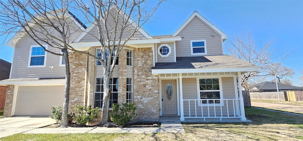 view of front of house with a garage, covered porch, and a front lawn