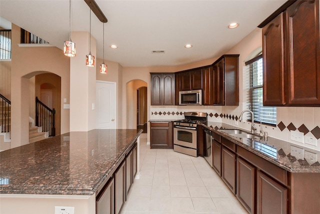 kitchen featuring dark stone countertops, sink, decorative backsplash, and stainless steel appliances