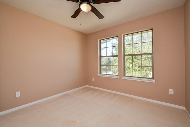 carpeted spare room featuring ceiling fan