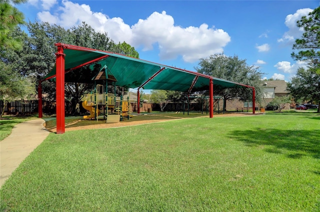 view of property's community with fence, playground community, and a yard