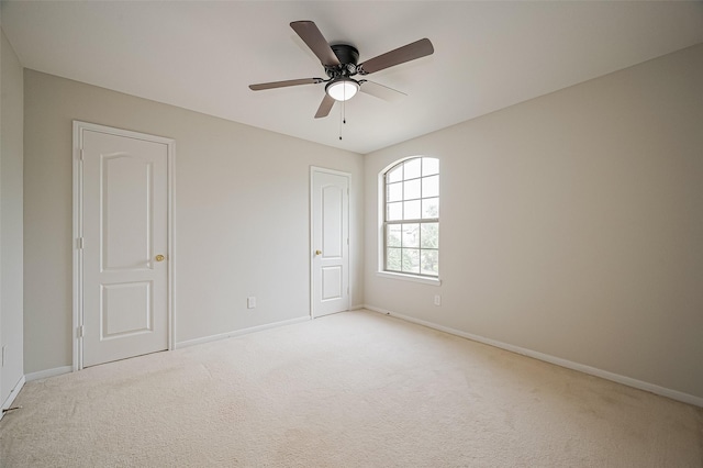 spare room with light carpet and baseboards