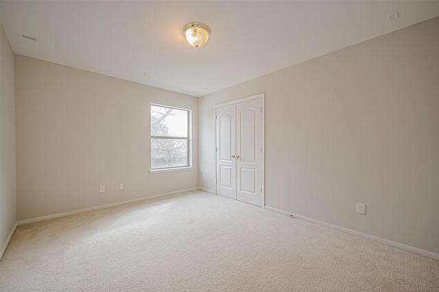 empty room with light carpet and baseboards