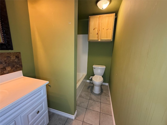 bathroom featuring a tub to relax in, tile patterned floors, toilet, and vanity