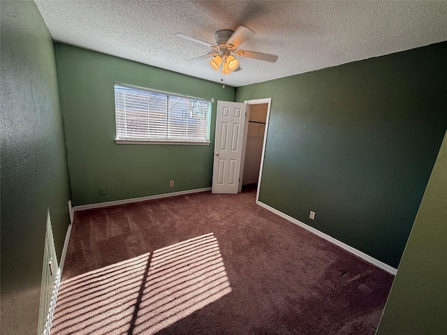 carpeted spare room featuring ceiling fan and a textured ceiling