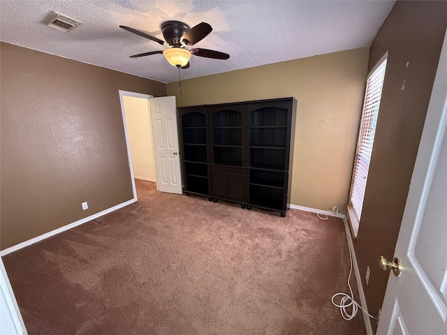 unfurnished bedroom with ceiling fan, carpet floors, and a textured ceiling