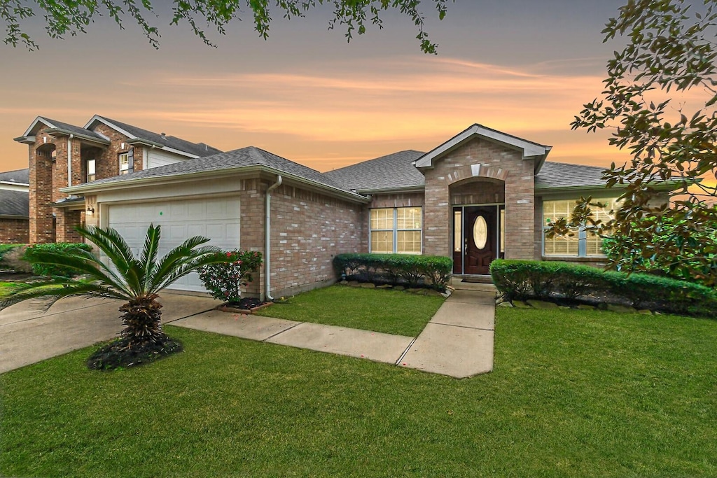 view of front of property featuring a yard and a garage