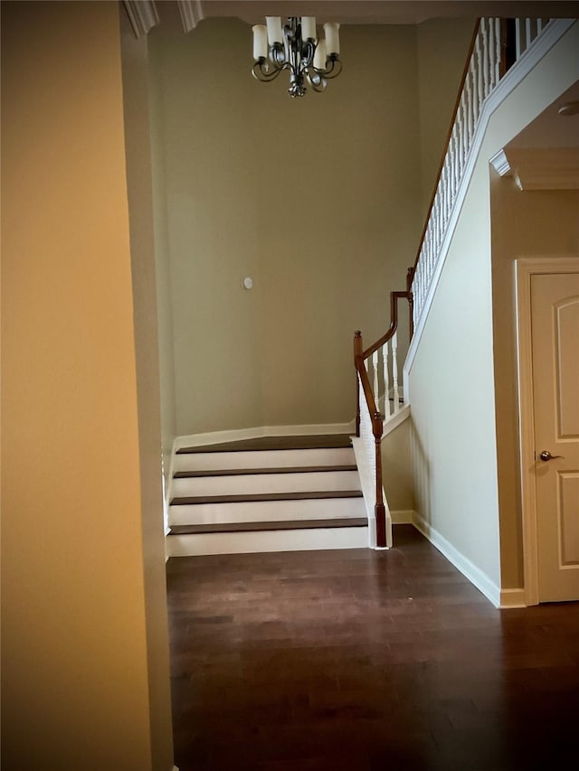 stairway featuring hardwood / wood-style floors and a notable chandelier