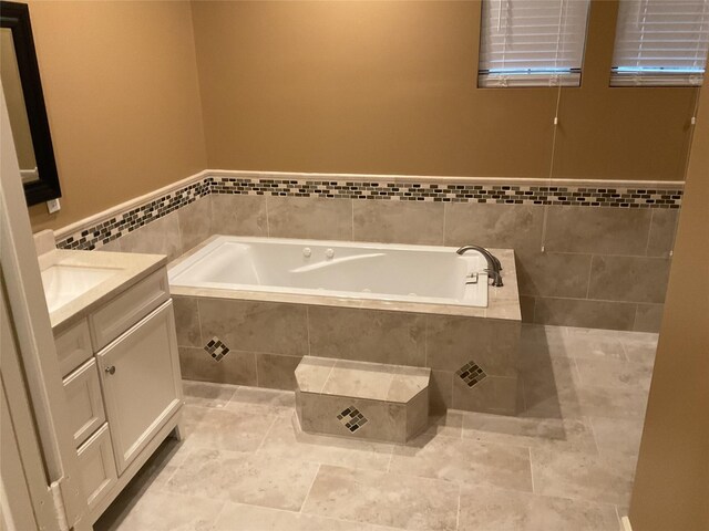 bathroom with vanity and tiled tub