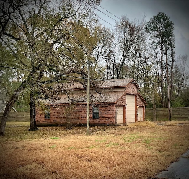 view of side of property with a garage and a lawn