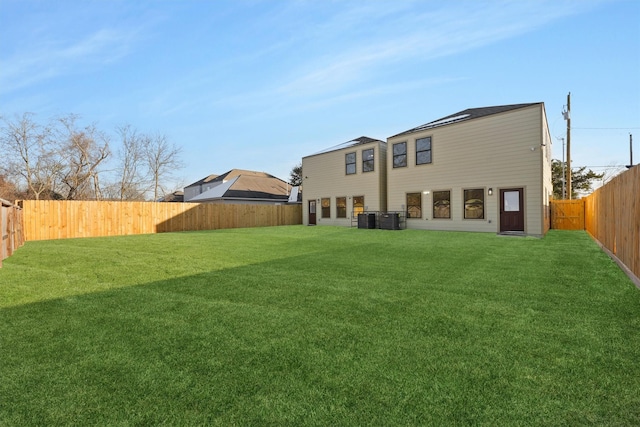 back of property with cooling unit and a yard