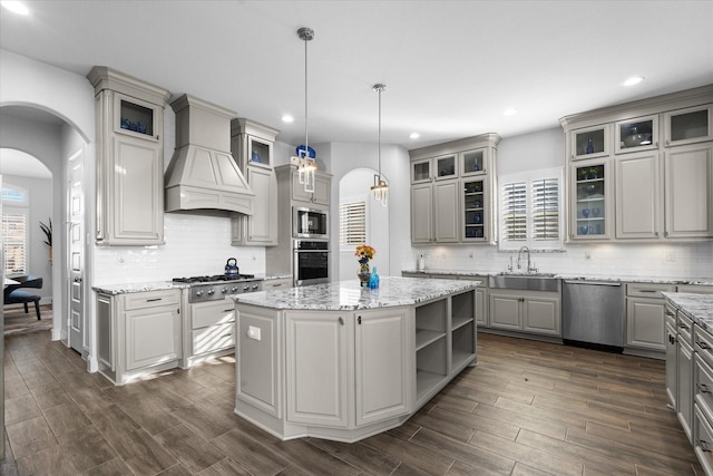 kitchen featuring custom exhaust hood, a center island, gray cabinets, pendant lighting, and stainless steel appliances