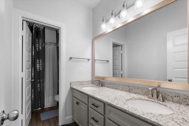 bathroom featuring hardwood / wood-style flooring, vanity, walk in shower, and toilet