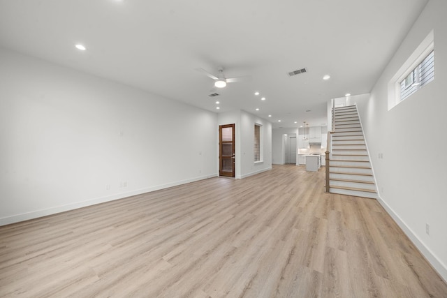 unfurnished living room featuring ceiling fan and light wood-type flooring