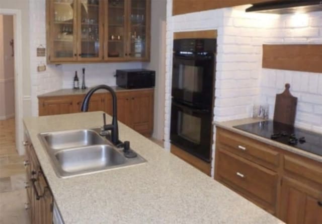 kitchen featuring tasteful backsplash, sink, exhaust hood, and black appliances