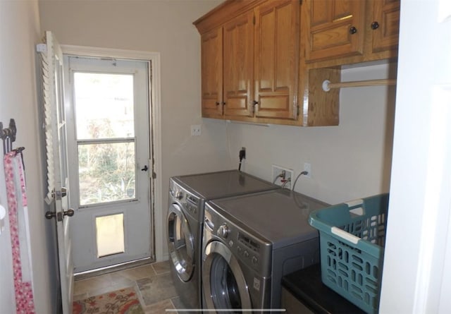 clothes washing area featuring cabinets and washer and clothes dryer