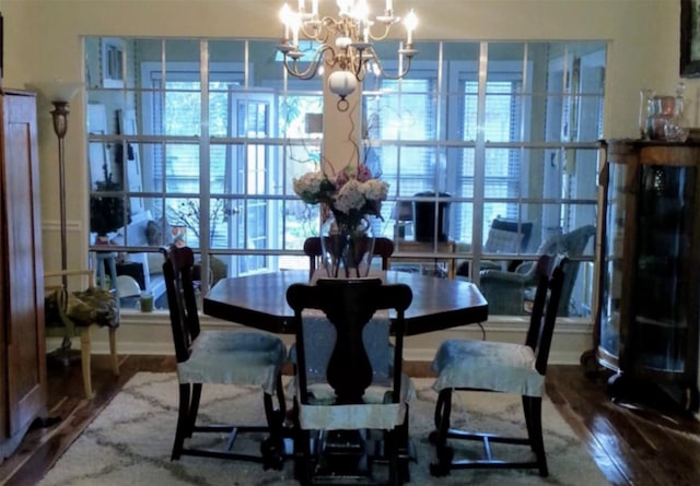 dining space featuring hardwood / wood-style flooring and a chandelier