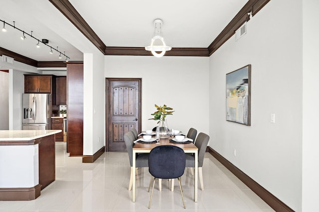 dining area featuring ornamental molding, rail lighting, and light tile patterned floors