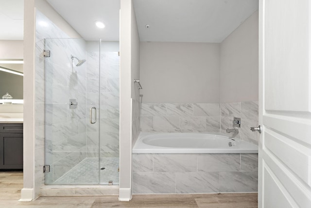 bathroom with vanity, hardwood / wood-style flooring, and shower with separate bathtub