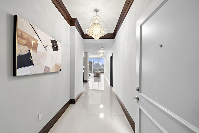 corridor with ornamental molding, a chandelier, and light tile patterned floors