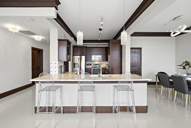 kitchen featuring hanging light fixtures, backsplash, stainless steel appliances, a kitchen bar, and kitchen peninsula