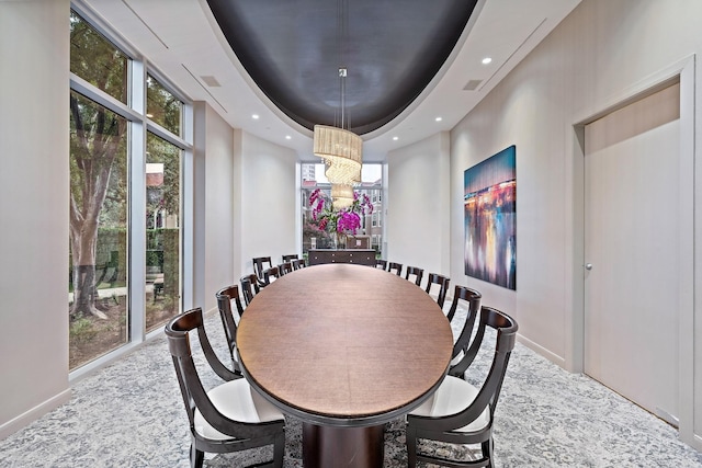 dining area featuring a raised ceiling and a chandelier