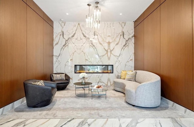 living area featuring an inviting chandelier and a high end fireplace