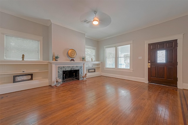 unfurnished living room featuring ornamental molding, hardwood / wood-style floors, ceiling fan, and a fireplace