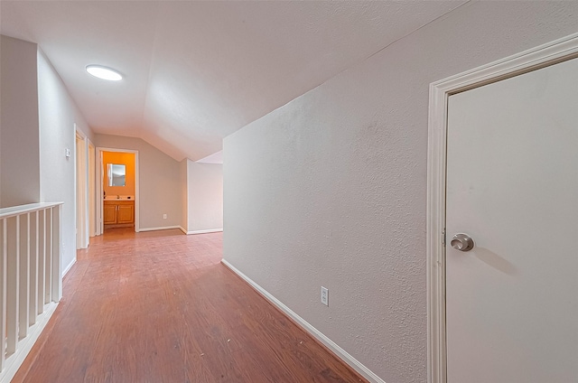 hall featuring hardwood / wood-style flooring and lofted ceiling