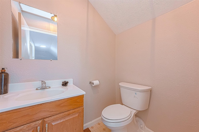 bathroom featuring vanity, a textured ceiling, and toilet