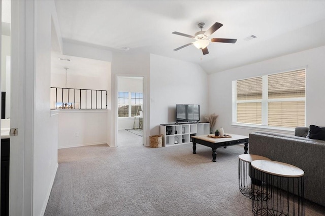 carpeted living room with ceiling fan and vaulted ceiling