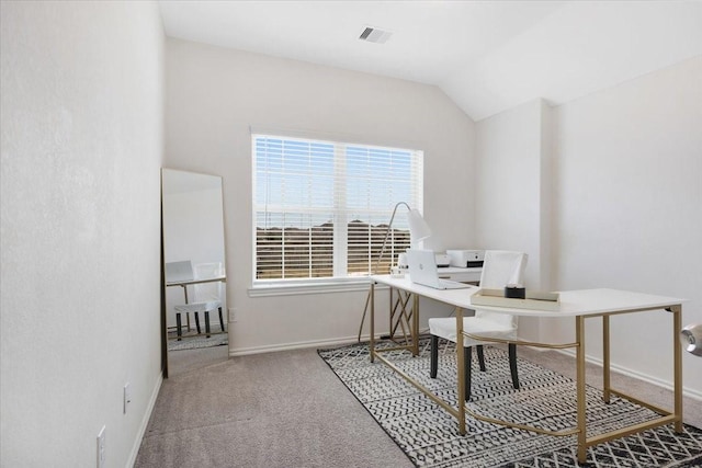 carpeted home office with vaulted ceiling