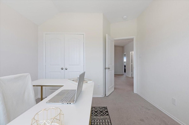 carpeted home office with vaulted ceiling