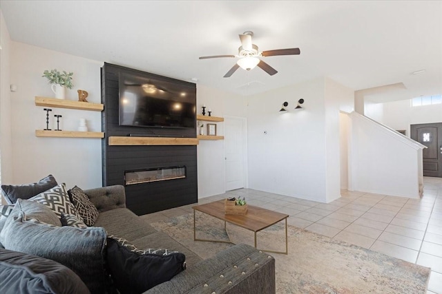 living room featuring light tile patterned floors, a fireplace, and ceiling fan