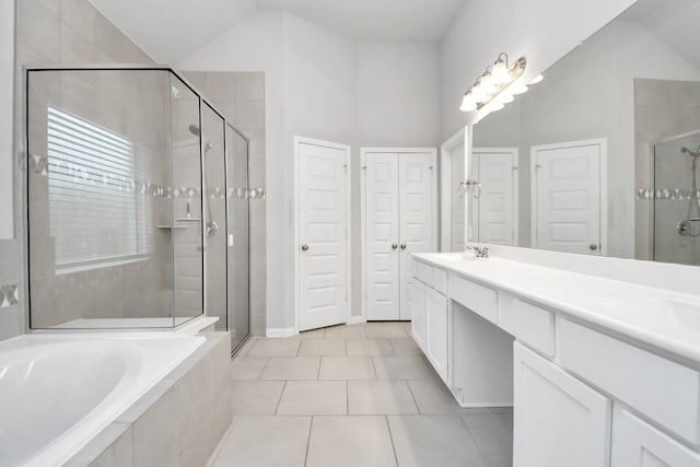 bathroom featuring tile patterned floors, vanity, plus walk in shower, and vaulted ceiling