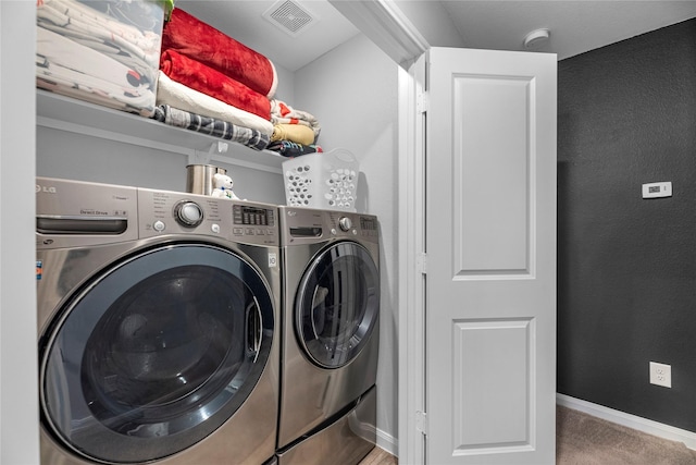 clothes washing area with washer and clothes dryer and carpet floors