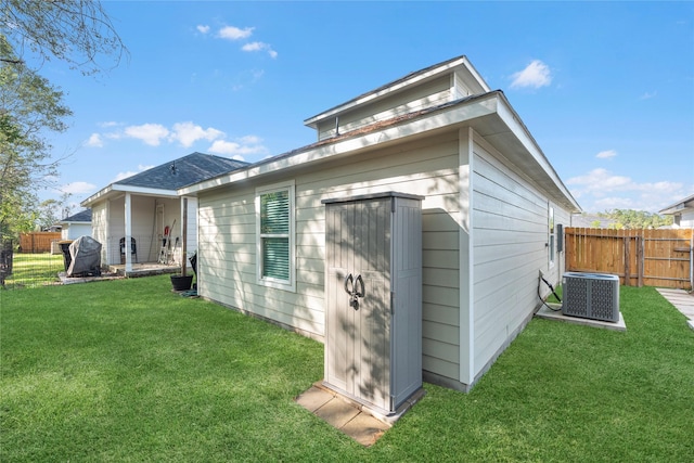 exterior space featuring a storage shed, central AC unit, and a lawn