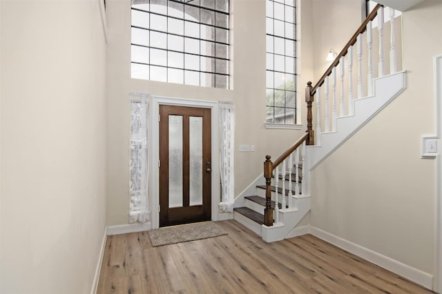 entrance foyer featuring light hardwood / wood-style flooring and a high ceiling