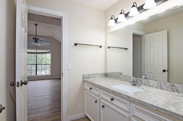 bathroom with ceiling fan, vanity, wood-type flooring, and lofted ceiling