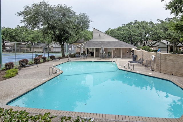 view of pool with tennis court