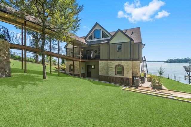 back of property with a yard and a water view