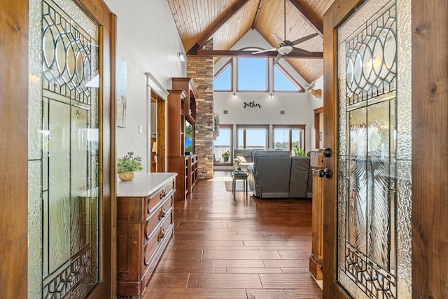 entrance foyer featuring dark wood-type flooring, high vaulted ceiling, wooden ceiling, ceiling fan, and beam ceiling