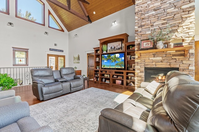 living room with french doors, a stone fireplace, hardwood / wood-style floors, and wooden ceiling