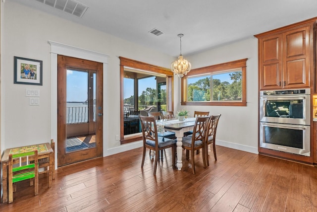 dining room featuring dark wood-type flooring and a notable chandelier