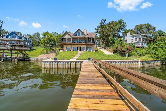 dock area featuring a balcony, a water view, and a yard